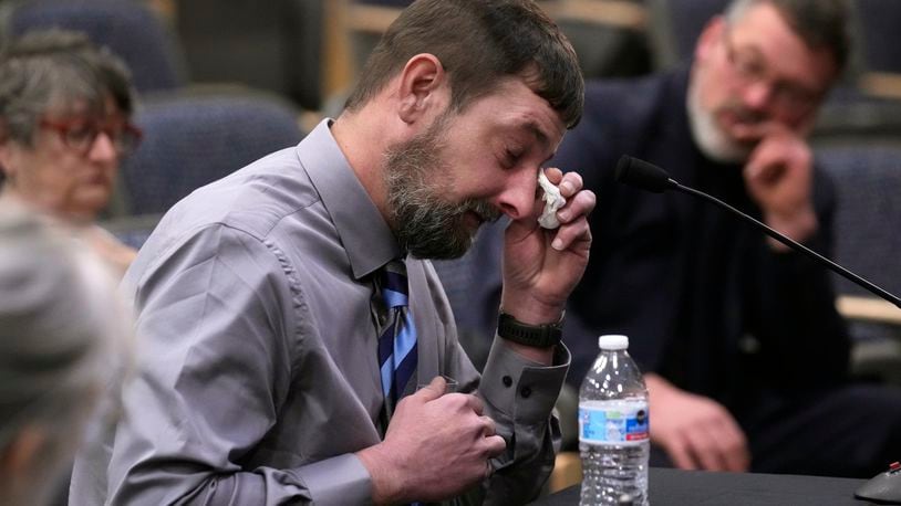 Sean Hodgson, a member of the U.S. Army Reserve, wipes tears while recalling the moment he heard about the mass shooting, Thursday, April 25, 2024, in Augusta, Maine, during a hearing of the independent commission investigating the law enforcement response to the mass shooting in Lewiston, Maine. (AP Photo/Robert F. Bukaty)