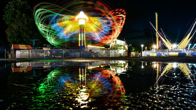 Light trails are visible from the rides in action at the Butler County Fair Monday, July 22, 2019 in Hamilton. NICK GRAHAM/STAFF