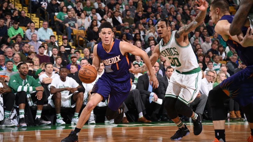 Devin Booker (1) of the Phoenix Suns drives to the basket against the Celtics on Friday in Boston.
