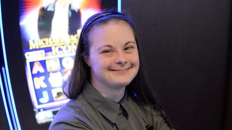 Kiersten Shelton, 24, of Fairfield, has worked at Miami Valley Gaming for about a year in housekeeping. She’s pictured in front of the Michael Jackson Icon slot machine on Thursday as Jackson is her favorite singer. Kiersten has Down syndrome and receives services through the Butler County Board of Developmental Disabilities, and was recommended for employment at the casino. MICHAEL D. PITMAN/STAFF