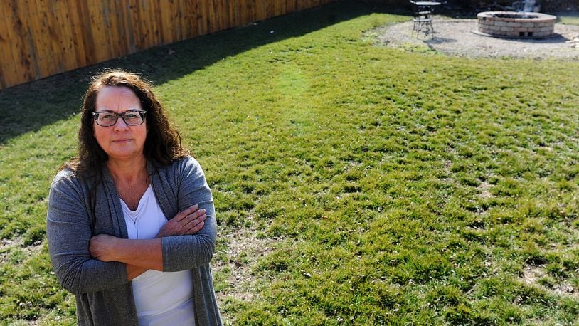 Missie Miller of Carlisle, is organizing an effort to stop Duke Energy from enforcing utility easements along its transmission lines in Carlisle. Miller stands where the easement goes into her yard. MARSHALL GORBY\STAFF