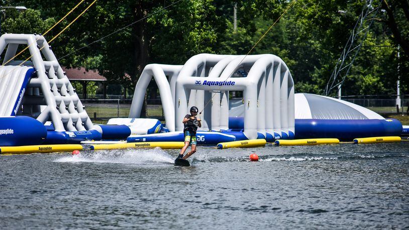 Participants learn new tricks at a wakeboarding youth camp Tuesday, July 7, 2020 at Wake Nation Cincinnati on Joe Nuxhall Boulevard in Fairfield. Wake Nation has an overhead cable system to pull wakeboarders around the pond and have added to their inflatable aqua park this year for those who are not interested in wakeboarding. NICK GRAHAM / STAFF