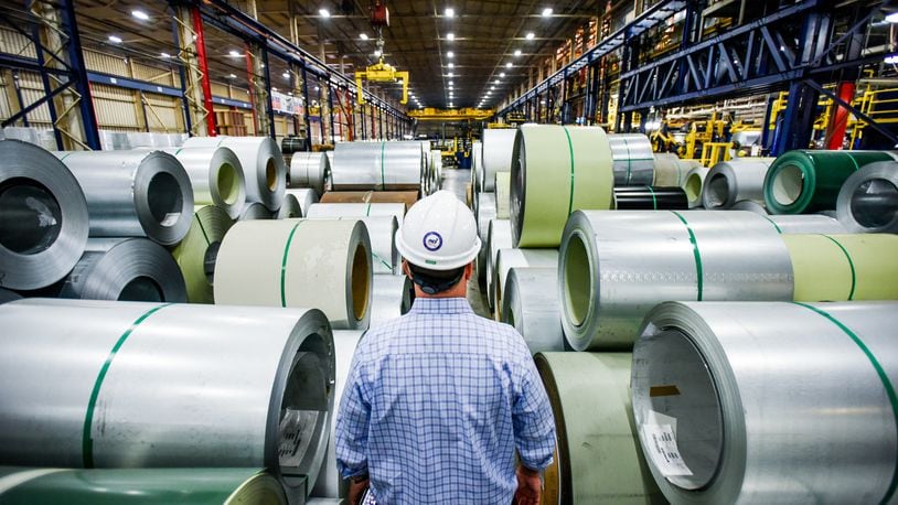 In this 2016 file photo, John Wallace, Vice President of Quality and Technical Systems at NCI Group Inc., walks between coils of steel that are lined up and ready to be coated at Metal Coaters in Middletown. NICK GRAHAM/STAFF 2016