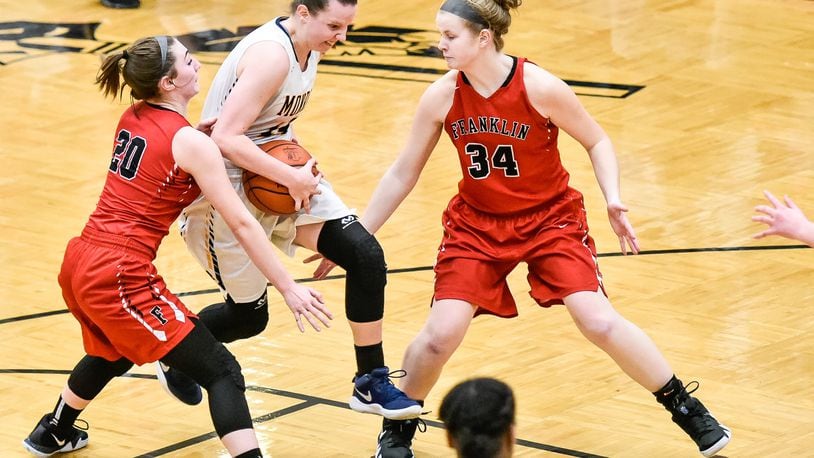 Monroe’s Sophie Sloneker drives to the hoop between Franklin’s Skyler Weir (20) and Brooke Stover (34) during their Division II sectional final Feb. 26 at Lebanon. NICK GRAHAM/STAFF