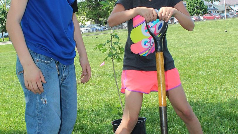 Hamilton residents and others are invited to participate in a double celebration of Earth Day and Arbor Day on Tuesday in Hamilton’s Riverside Natural Area, which is under development. Last year, these students planted a tree near their school. JEFF GUERINI/STAFF