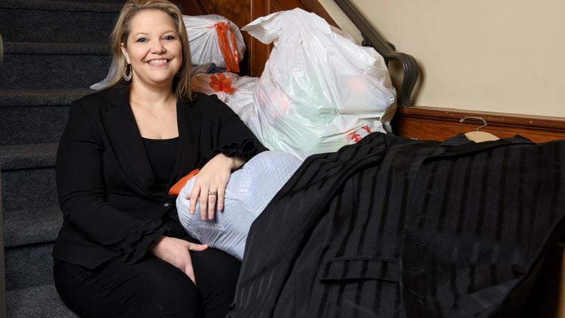 Jeri Lewis sits among clothing donations for her new non-profit venture, Job Threads, geared toward supplying dress clothing for unemployed people for interviews. NICK GRAHAM / STAFF
