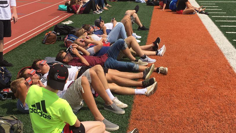 Students from Waynesville schools watch Monday’s solar eclipse on the high school’s football field. JEREMY P. KELLEY / STAFF