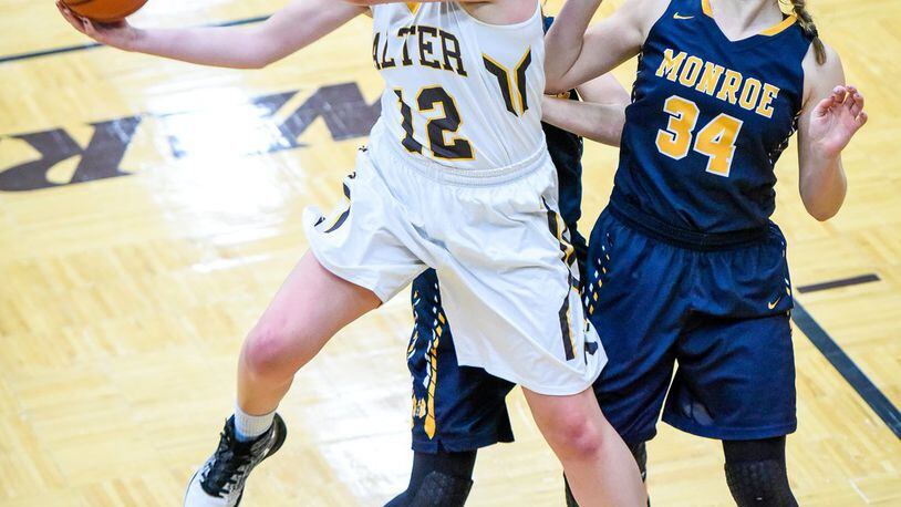 Alter’s Nicole Hoeflinger drives to the hoop while being defended by Monroe’s Erica Thompson (34) and Kylee Slone during their Division II sectional final Thursday night at Lebanon. NICK GRAHAM/STAFF