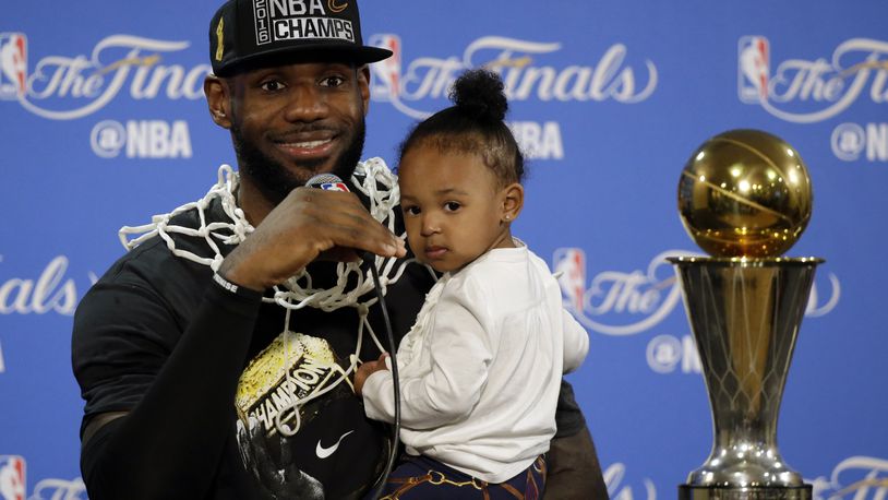 The Cavaliers’ LeBron James answers questions as he holds his daughter Zhuri during a post-game press conference after Game 7 on Sunday, June 19, 2016, in Oakland, Calif. (AP Photo/Eric Risberg)