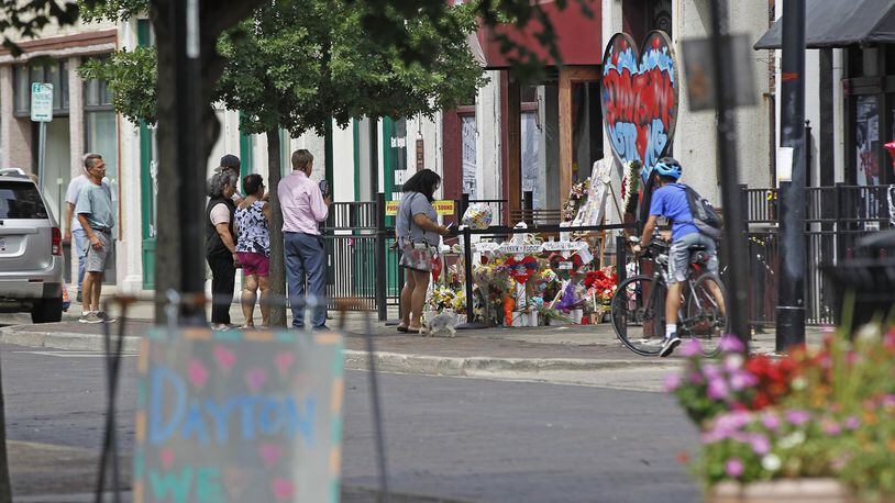 Memorials to victims of the mass shooting on August 4 have begun to shrink in the Oregon District and some business owners would like to have them removed. Many people continued to visit the memorials during the Friday lunch hour. TY GREENLEES / STAFF