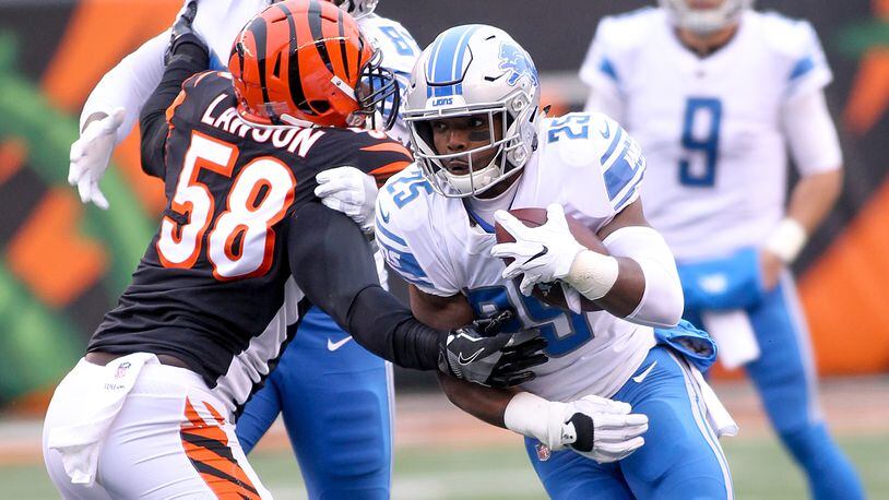CINCINNATI, OH - DECEMBER 24: Theo Riddick #25 of the Detroit Lions runs with the ball past Carl Lawson #58 of the Cincinnati Bengals during the first half at Paul Brown Stadium on December 24, 2017 in Cincinnati, Ohio. (Photo by John Grieshop/Getty Images)