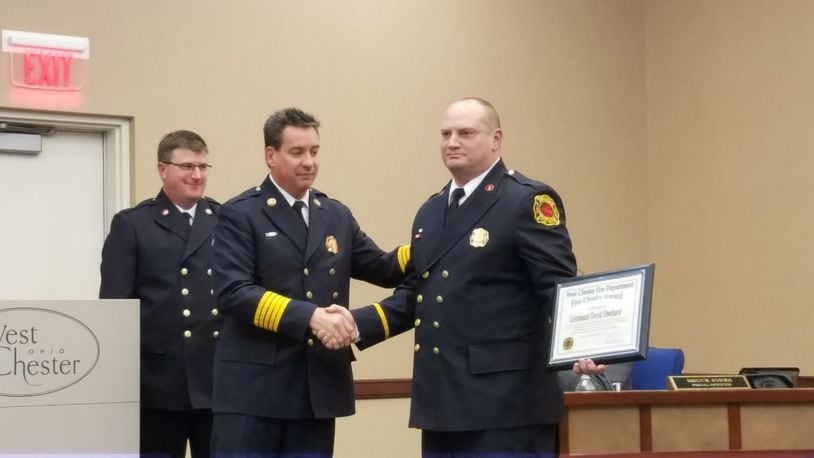 West Chester Township Fire Department Lt. David Eberhard (right) was presented the “Fire Chief’s Award” for his role in being first on the scene to save a choking infant at a local restaurant in early December. Eberhard, shown being congratulated at a recent township trustees’ meeting by Fire Chief Rick Prinz, is the first firefighter to win the rare award since 2007.