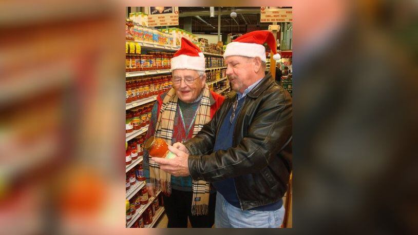 Fairfield Rotary members John Brunner, left, and Jeff Holtegel shopped at Jungle Jim’s to buy food for families the service organization supported in a past annual Christmas Project shopping day. The Rotary provides a Christmas dinner and presents for Fairfield area families in need. The project is funded through the Rotary’s annual Spring Charity Auction, which is on April 17 in 2020. FILE/PROVIDED
