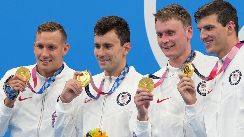 From left, Caeleb Dressel, Blake Pieroni, Bowen Becker and Zach Apple of the United States wear their gold medals during the medal ceremony for the men’s 4x100-meter freestyle relay, at the Tokyo Aquatics Centre during the delayed 2020 Olympics in Tokyo, July 26, 2021. (Doug Mills/The New York Times)