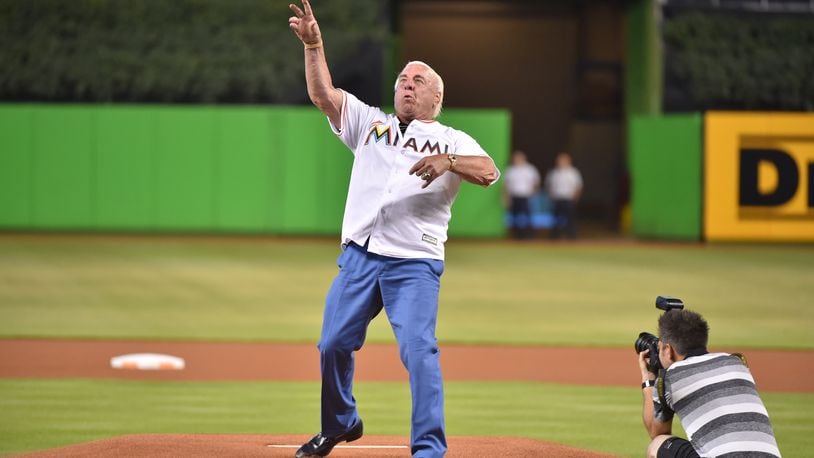 Former pro wrester Ric Flair throws out the first pitch before the start of the Friday game between the Reds and the Marlins at Marlins Park. He's have probably been more accurate if he were leaping off a turnbuckle. Might have been a good idea for the “Nature Boy” to focus on his target instead of the stars.