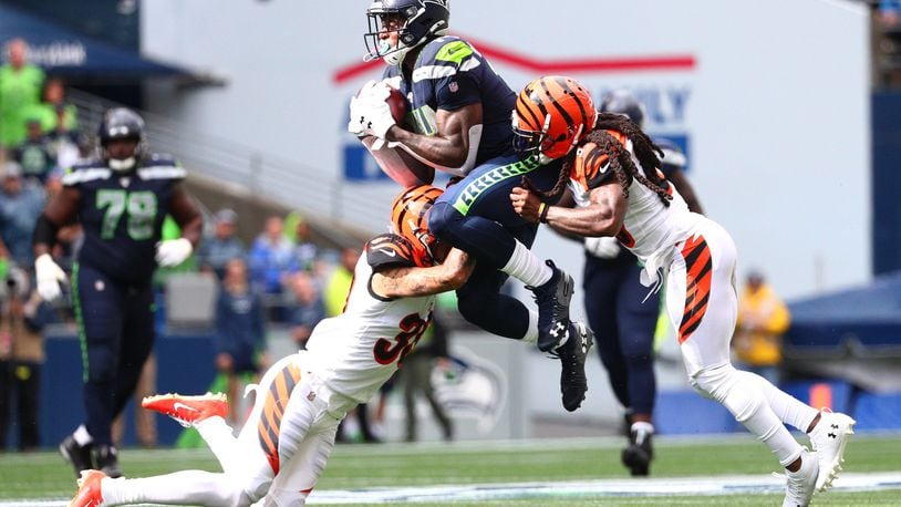SEATTLE, WASHINGTON - SEPTEMBER 08: D.K. Metcalf #14 of the Seattle Seahawks completes a pass against Jessie Bates #30 (L) and B.W. Webb #23 of the Cincinnati Bengals in the third quarter during their game at CenturyLink Field on September 08, 2019 in Seattle, Washington. (Photo by Abbie Parr/Getty Images)