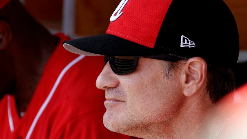 Cincinnati Reds manager David Bell watches from the dugout during the first inning of a spring training baseball game against the Milwaukee Brewers, Sunday, March 3, 2019, in Phoenix. (AP Photo/Charlie Riedel)