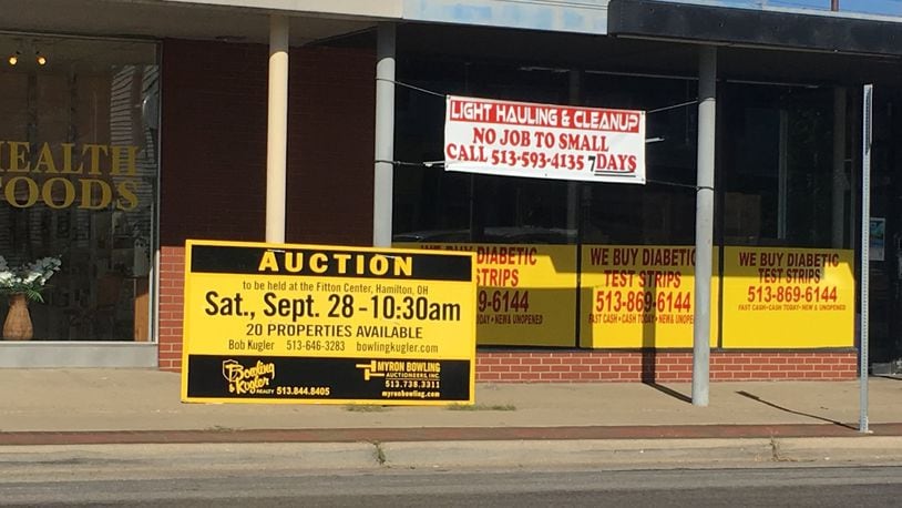 Auction signs like this were up this summer on properties offered in the estate auction of a Hamilton dermatologist. The buyers of one of those buildings now under contract plan to create a restaurant. MIKE RUTLEDGE/STAFF