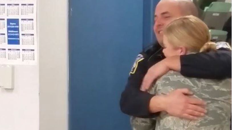 Middlwtown police officer John Palmer hugs his daughter, Airman McKinley Palmer, during a surprise visit on Christmas Eve.