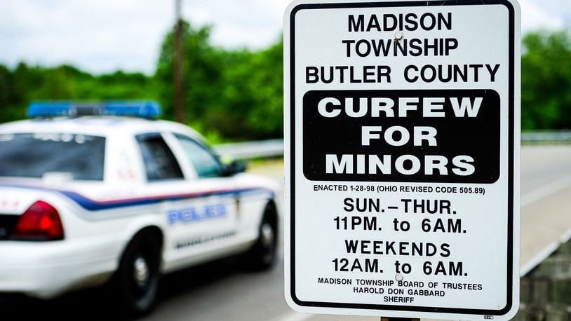 A sign displaying curfew times for minors is on display along Ohio 122 entering Madison Twp. NICK GRAHAM/STAFF