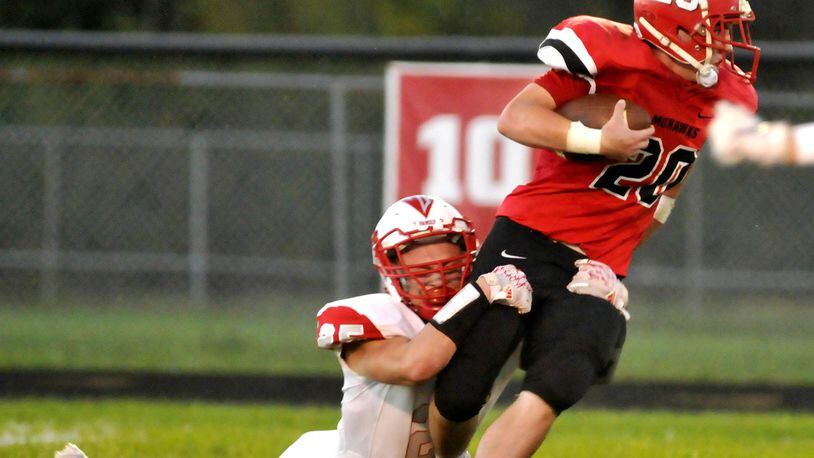 Madison’s Ryan Friend (20) is brought down from behind by Carlisle’s Dane Flatter (25) during their Oct. 7 game at Brandenburg Field in Madison Twp. CONTRIBUTED PHOTO BY DAVID A. MOODIE