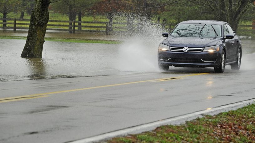 A car splashes through water from a flooded yard covering part of Millikin Road between Yankee and Cincinnati Dayton roads in 2011 in Liberty Twp. For at least 60 years flood waters have wrecked havoc along Millikin Road between Cincinnati Dayton and Yankee roads, pushing way past the road limits, deluging lawns and basements and stalling cars trying to get through. This week the Butler County commissioners signed off on a $980,279 contract to fix the problem. NICK GRAHAM/STAFF