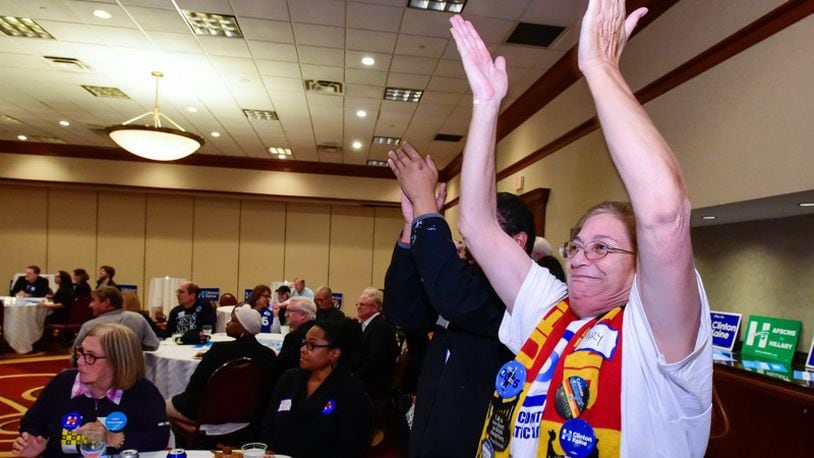 Mary Williams, right, and Will Goins cheer as a state is called in Hillary Clinton’s favor during the Butler County Democratic party election results watch event Tuesday, Nov. 8 at the Marriott ballroom in West Chester Twp. NICK GRAHAM/STAFF