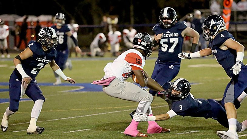 Edgewood defensive back Nick Noble hangs on to Mt. Healthy’s Tyree Roberson as EHS teammates D.J. Whiles (2), Greg Dingledine (57) and (4) Evan Brown come in to assist during their game in Trenton on Oct. 28, 2016. Edgewood won 49-28. CONTRIBUTED PHOTO BY E.L. HUBBARD