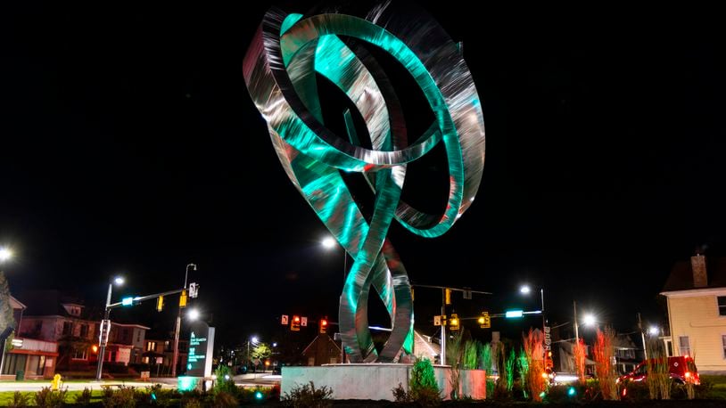 A dedication ceremony was held Wednesday, Nov. 3, 2021 for the 25-foot-tall ‘Embrace’ sculpture, by artist Hunter Brown, which was installed at the newly reconfigured intersection of Main Street with Millville and Eaton avenues in 2020. New lights were installed to illuminate the metal sculpture that can be changed multiple colors. NICK GRAHAM / STAFF