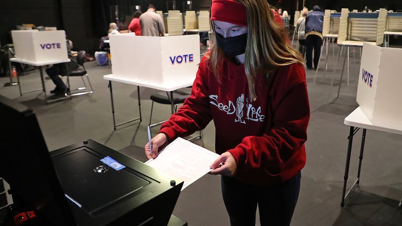 Clark County resident Grace Storck slides her ballot into the voting machine after casting her vote for the very first time Saturday at the Clark State Performing Arts Center. Grace said she's a student at Wilmington College and didn't think she could get back on Tuesday for election day. BILL LACKEY/STAFF