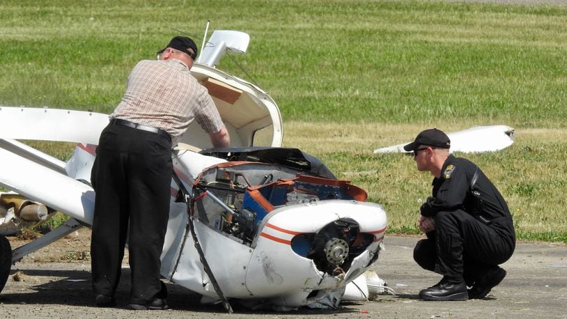 Emergency crews and investigators look over an airplane that crashed at Butler County Regional Airport, Tuesday, May 15. Henry Rosche III, 63, of Loveland, was injured in the crash when his 1974 Grumman plane experienced engine failure, according to the Ohio Highway Patrol. NICK GRAHAM/STAFF