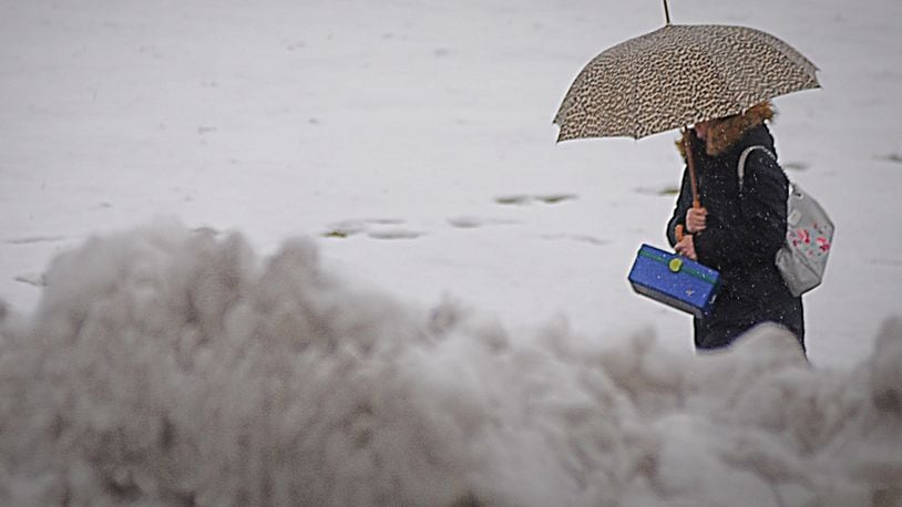 A woman tries to stay dry on a cold and windy day in January in Huber Heights. Photo Marshall Gorby