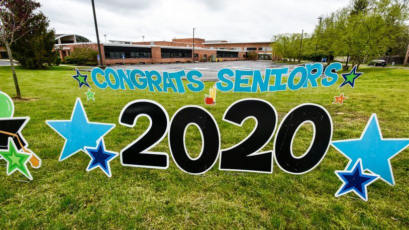 Hamilton High School seniors picked up their caps and gowns Thursday, April 30, 2020 at Hamilton High School in Hamilton. The seniors and parents were greeted by signs drove through balloon arches as they picked up their graduation supplies in drive-thru fashion. Schools around the area are still trying to figure out how to make graduations ceremonies special for students while keeping with the social distancing guidelines. Hamilton has not announced their plans yet for graduation. NICK GRAHAM / STAFF