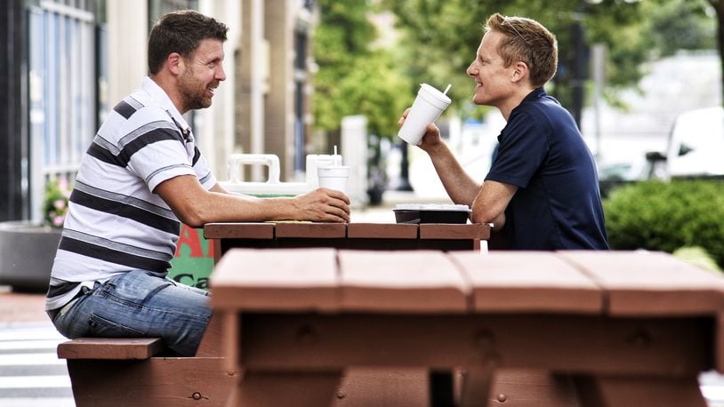 Matt Tucker, left, and Rick Meyer eat lunch at the picnic tables set up for outdoor dining along High Street in downtown Hamilton Thursday, Sept. 3, 2020. NICK GRAHAM / STAFF