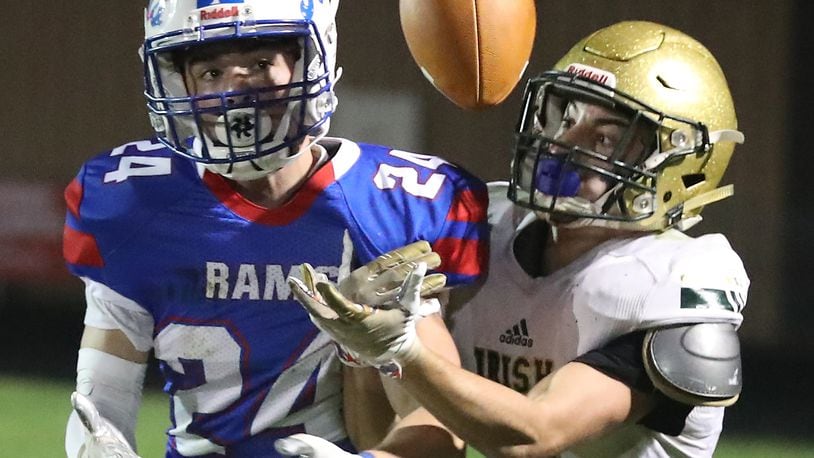Greeneview's Craig Finley and Catholic Central's Ashton Young battle for a pass during Friday's game. BILL LACKEY/STAFF