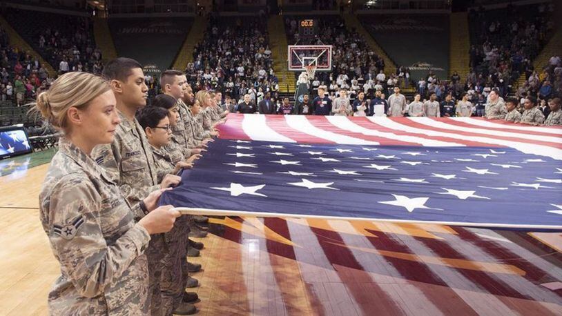 Airmen from Wright-Patterson Air Force Base hold a large American flag during a pregame ceremony prior to a Wright State University basketball game at the Nutter Center. The college hosted a military appreciation night. (U.S. Air Force photo/R.J. Oriez)
