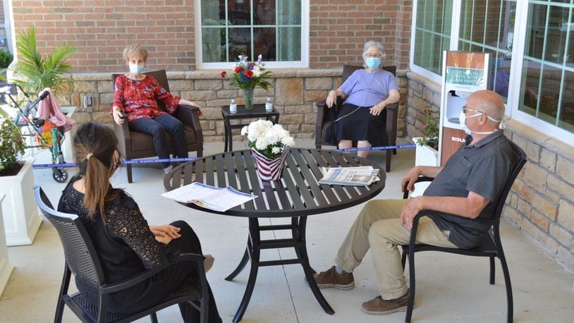 Randall Residence of Centerville residents and workers sit outside at the courtyard, where visitors will soon be able to meet with loved ones from a distance. CONTRIBUTED