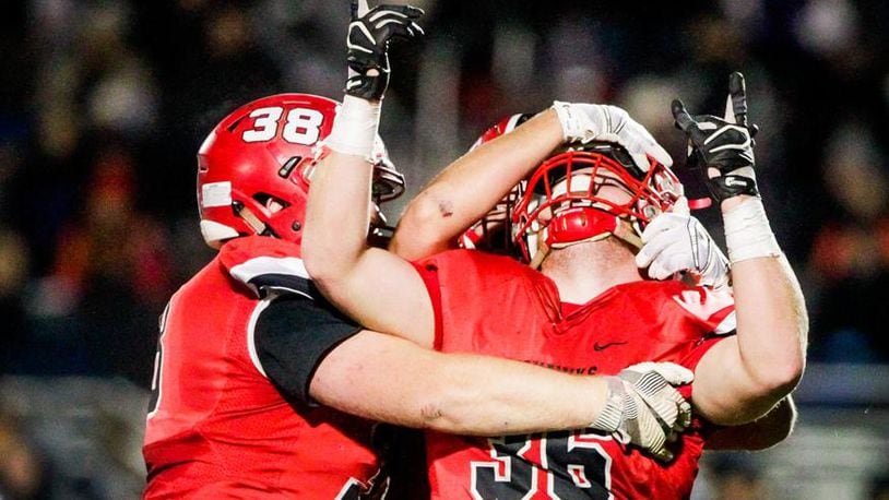 Madison’s Max Evans (38) and Cole Pelgen do some celebrating Saturday night during the Mohawks’ 50-6 victory over Cincinnati Hills Christian Academy in a Division V, Region 20 semifinal at Lakota East. NICK GRAHAM/STAFF