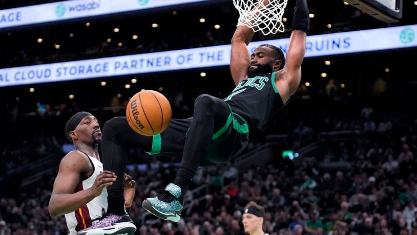 Boston Celtics guard Jaylen Brown, right, slams a dunk against Miami Heat center Bam Adebayo (13) during the first half of Game 5 of an NBA basketball first-round playoff series, Wednesday, May 1, 2024, in Boston. (AP Photo/Charles Krupa)
