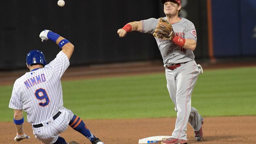 New York Mets’ Brandon Nimmo (9) is out at second as Cincinnati Reds second baseman Scooter Gennett relays the ball to first to complete the double play on Juan Lagares during the fourth inning of a baseball game Saturday, Sept. 9, 2017, in New York. (AP Photo/Bill Kostroun)