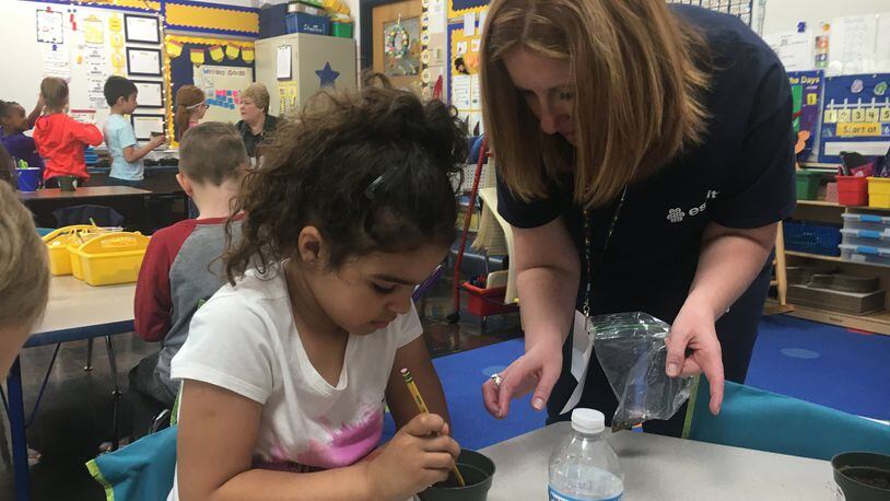 Kindergarten student Arilyn McNair plants a “tickle me” seed with assistance from her teacher, Emily Young, during an Earth Day project Monday at Monroe Primary School. The program was sponsored by Essity Paper in Middletown. RICK McCRAB/STAFF