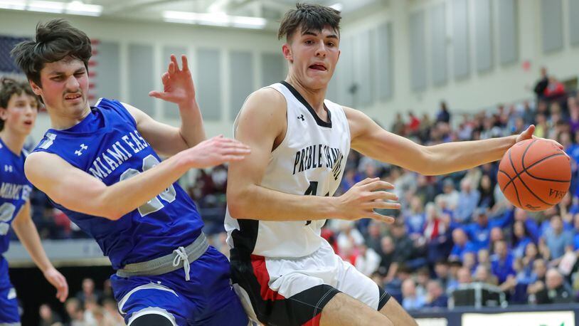 Preble Shawnee High School junior Logan Hawley collides with Miami East junior Devon Abshire during their Division III regional semifinal game on Wednesday night at Kettering's Trent Arena. The Arrows won 50-40. CONTRIBUTED PHOTO BY MICHAEL COOPER