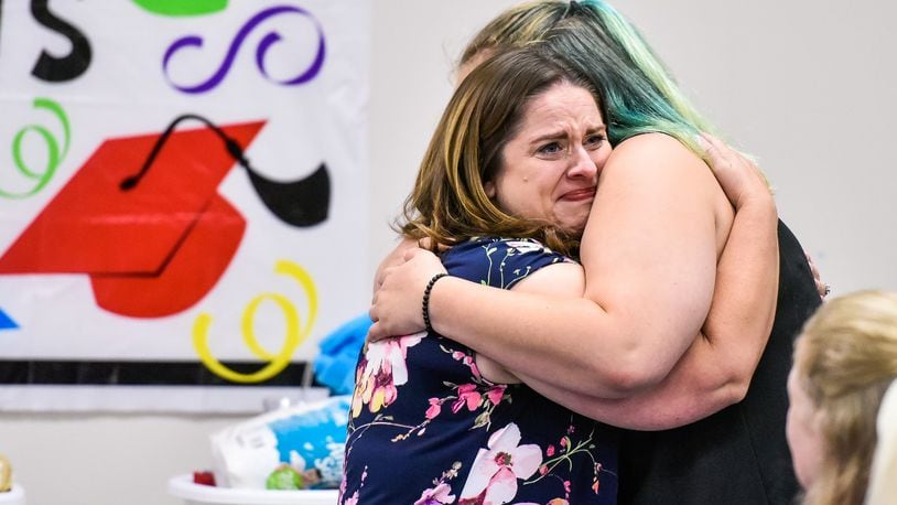 Case worker Amanda Hinkle, left, congratulates Corina Jean on her graduation during the Butler County Children Services graduation ceremony for kids involved in the foster care program Thursday, June 21 in Hamilton. Corina graduated from Belmont High School and plans to attend Sinclair Community College to be a pharmacy tech. NICK GRAHAM/STAFF