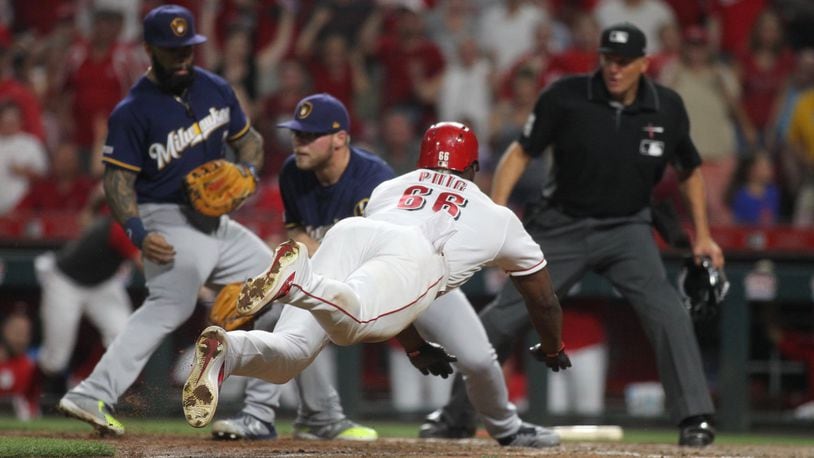 The Reds’ Yasiel Puig scores the winning run against the Brewers on Tuesday, July 2, 2019, at Great American Ball Park in Cincinnati. David Jablonski/Staff