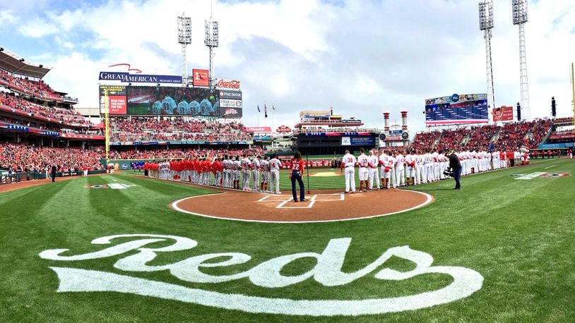 The Reds and Nationals stand for the national anthem on Opening Day on Friday, March 30, 2018, at Great American Ball Park in Cincinnati. David Jablonski/Staff