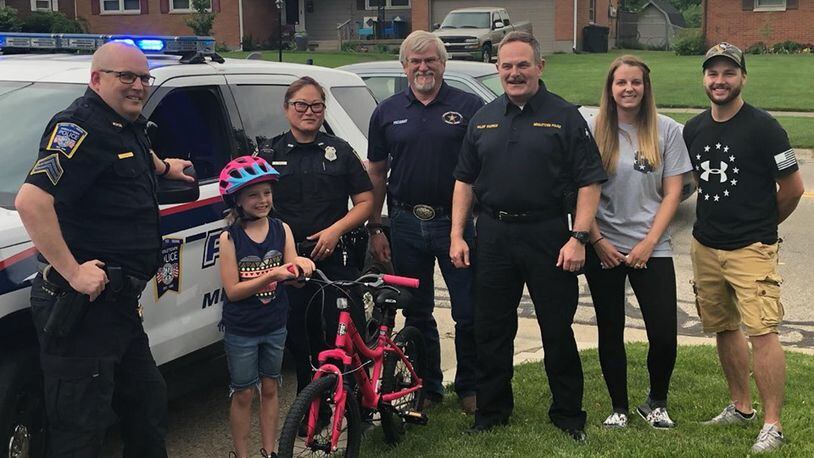 Members of the Middletown Division of Police and FOPA President Perry Davis presented Raelyn Basham with a new bike Wednesday after the bike she received for Easter was stolen Monday. SUBMITTED PHOTO