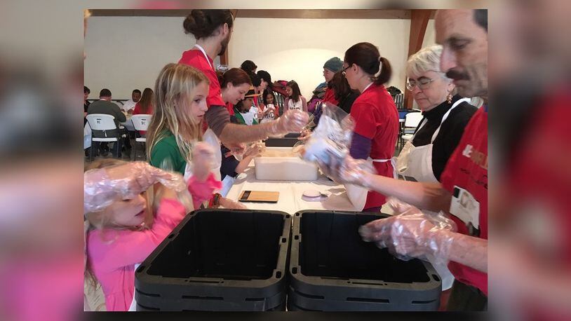 About 60 children and adults helped prepare meals at the First Presbyterian Church in Yellow Springs Thursday Dec. 27, 2018. The goal of the event, hosted by Kid Scouts Inc. and Hunger Van, was to prepare 10,000 meals that will be distributed to people in need. RICHARD WILSON/STAFF