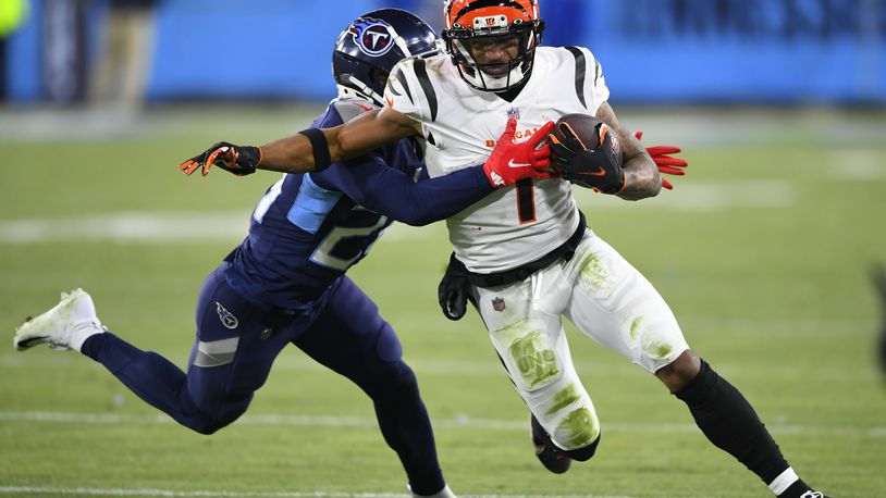 Tennessee Titans cornerback Janoris Jenkins (20) tackles Cincinnati Bengals wide receiver Ja'Marr Chase (1) during the second half of an NFL divisional round playoff football game, Saturday, Jan. 22, 2022, in Nashville, Tenn. (AP Photo/John Amis)