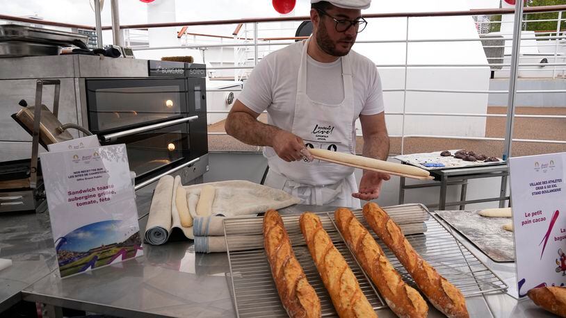 French baker Tony Dore prepares baguettes, like those that will be served during the. Olympic Games, Tuesday, April 30, 2024 in Paris. Some 40,000 meals will be served each day during the Games to over 15,000 athletes housed at the Olympic village. (AP Photo/Michel Euler)