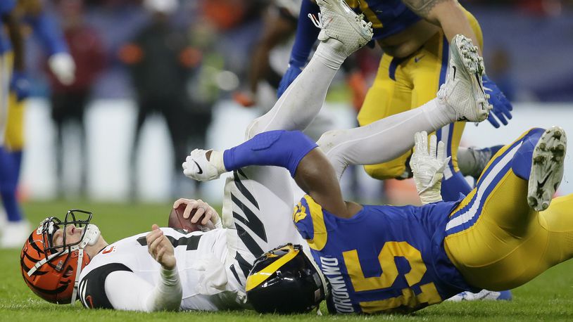 Cincinnati Bengals quarterback Andy Dalton, left, is sacked by Los Angeles Rams linebacker Obo Okoronkwo during the second half of an NFL football game, Sunday, Oct. 27, 2019, at Wembley Stadium in London. (AP Photo/Tim Ireland)